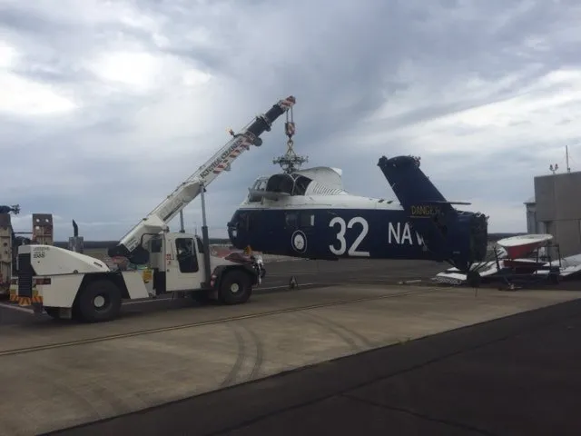 Aircraft lifted beside a hangar