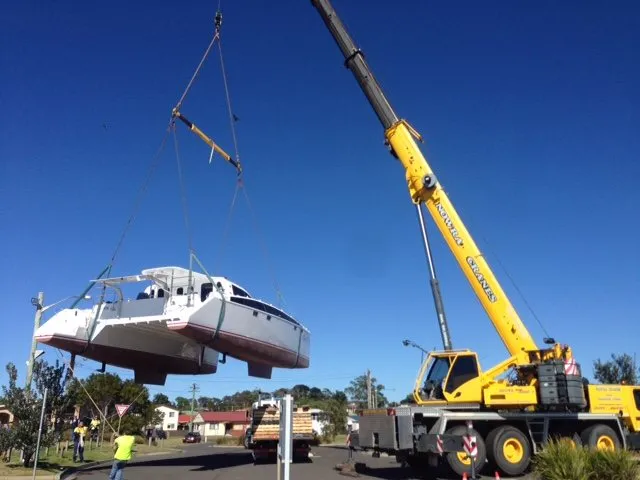 Catamaran lifted over a suburban street