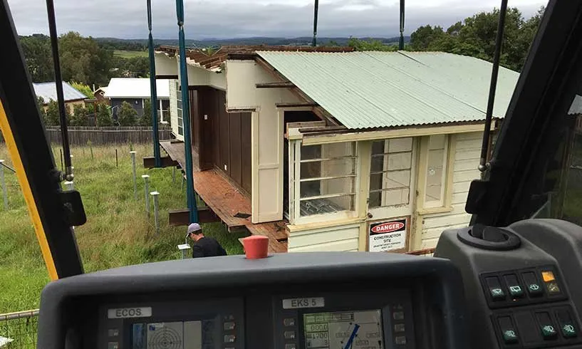 House lowered onto its truck, seen from the crane cab